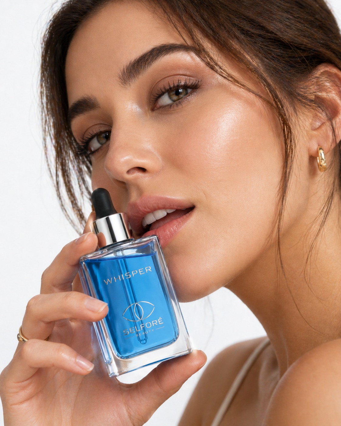A woman holding the Whisper bottle close to her face, glowing skin, soft focus